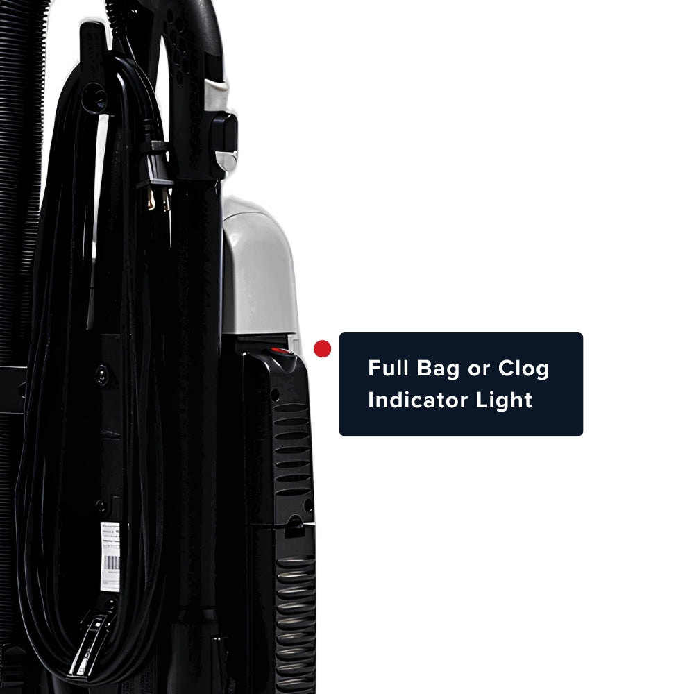 Close-up of a vacuum cleaner showing a black cord, hose, and canister with a white light housing, plus a text callout that reads 'Full Bag or Clog Indicator Light' on a white background.