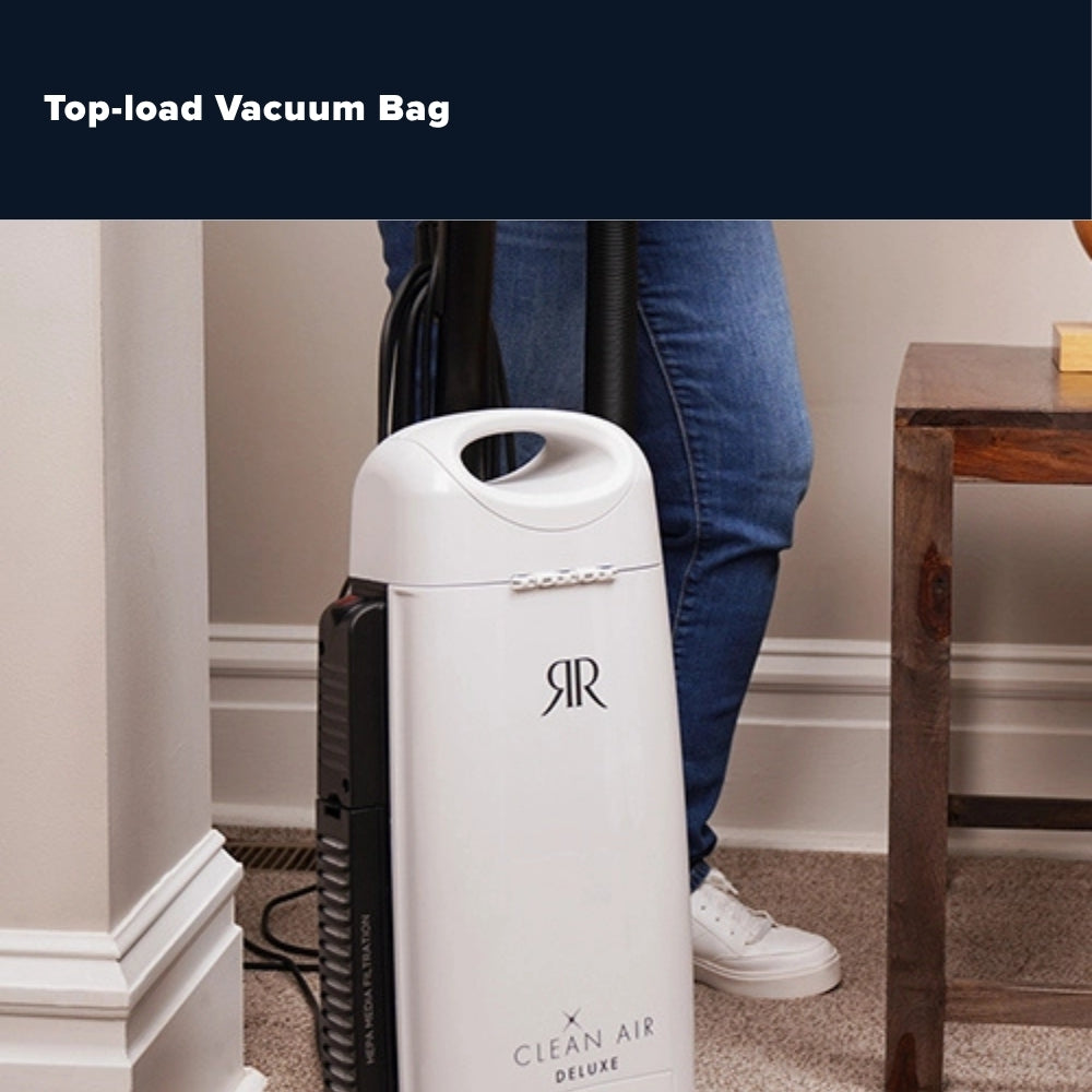 A white top-load vacuum bag with a black side panel and hose, shown in a home setting with a person's legs visible behind it. The text 'Top-load Vacuum Bag' appears at the top of the image.