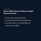 A dark navy promotional graphic with white text reading 'US VACUUMS' and 'Riccar Clean Air Premium Pet Upright Vacuum Cleaner,' plus three warranty bullet points.