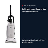 A Riccar upright vacuum cleaner shown on a split white and dark navy promotional graphic with text highlighting Clean Air technology and upholstery, dusting, and crevice use.